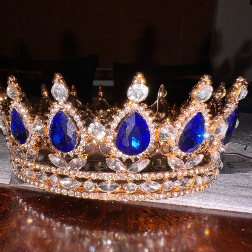 Gold tone crown with white and blue gems